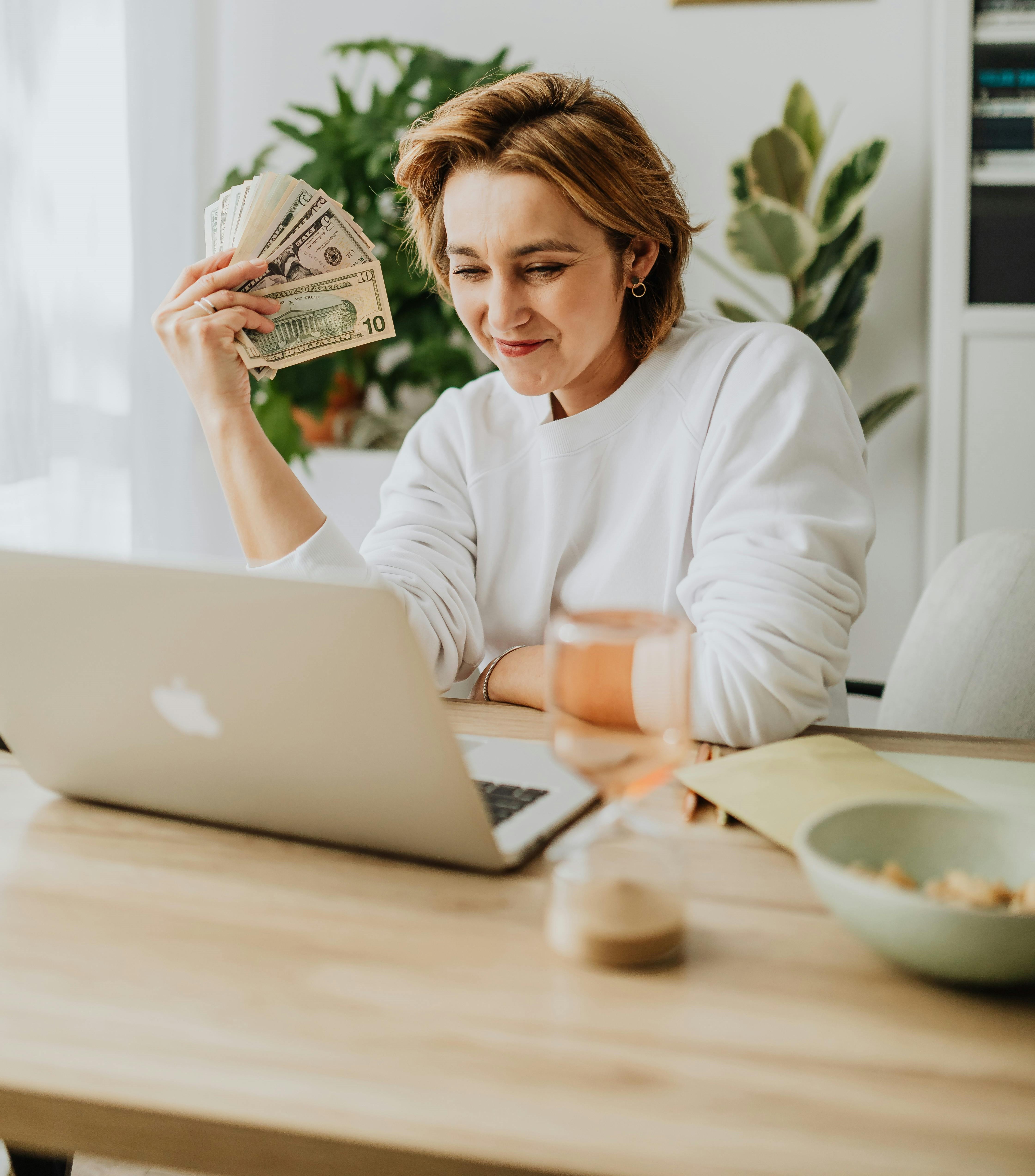 Freelance woman smiling while working on a laptop.